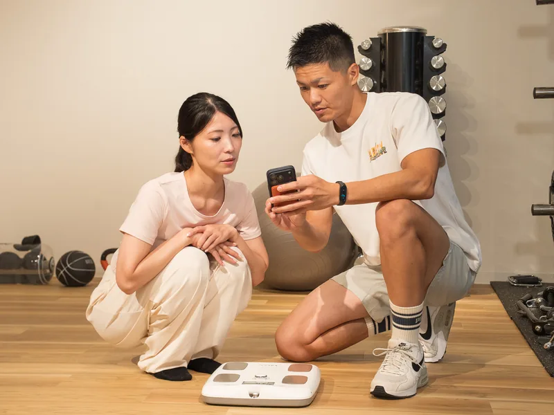 Happilyで身体の測定結果をトレーナーと確認する女性