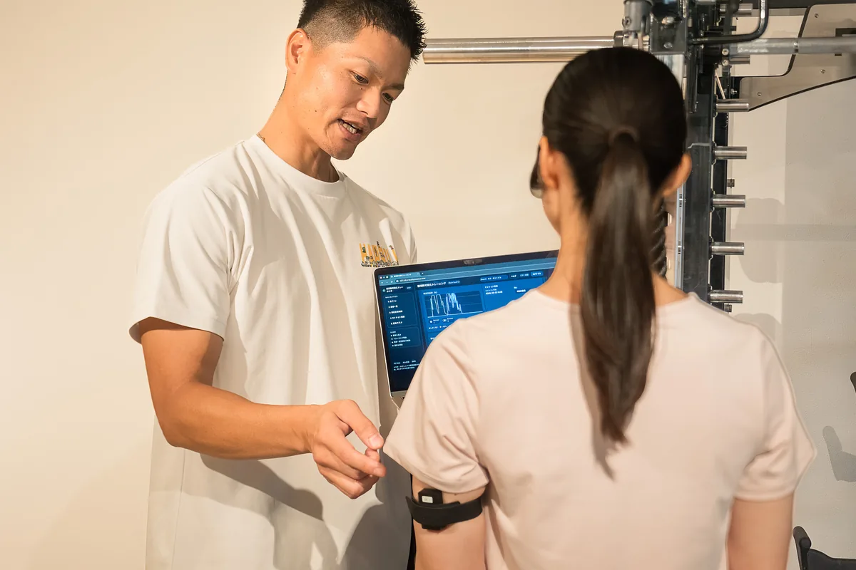 Happilyで筋電計測の結果をトレーナーと確認する女性